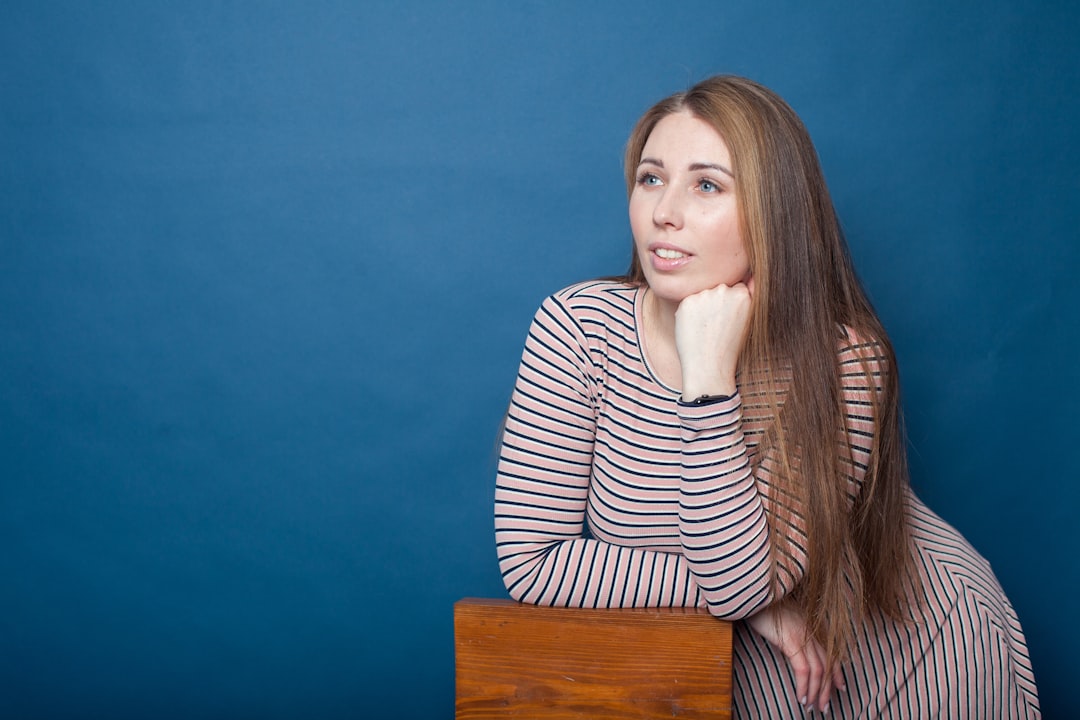 頭に手を当てて考え込む女性